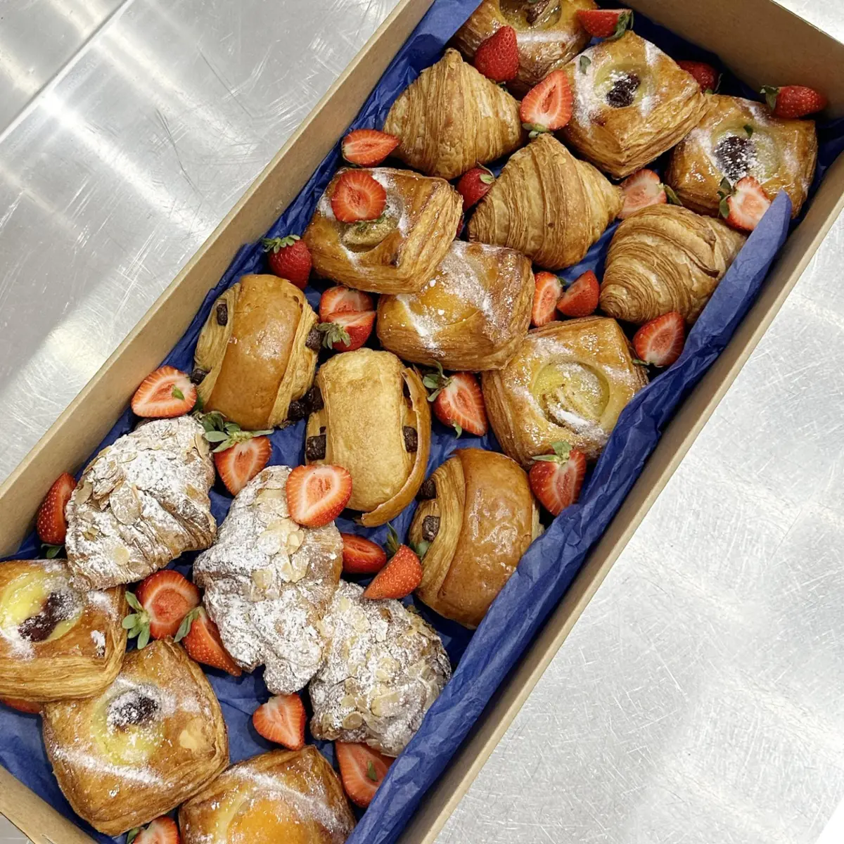 Mixed dessert platter of croissants, danishes and pastries in a catering box